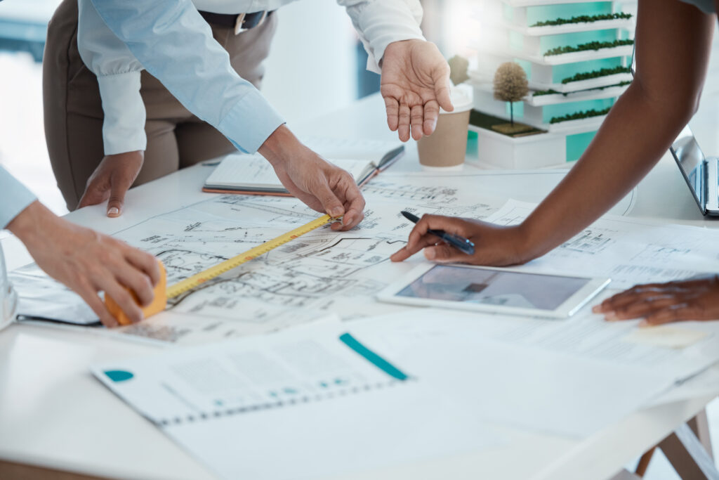 Blueprint, construction and architect team planning in meeting, drawing on paper and collaboration for building project. Hands working in architecture with strategy on document and tablet in office